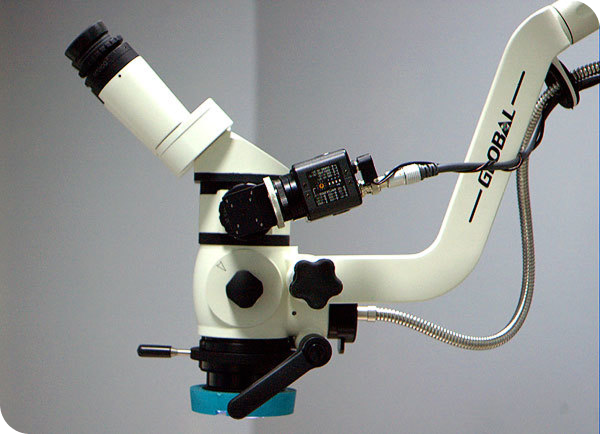Close-up of a modern microscope with adjustable arm and camera, ideal for detailed scientific observations.